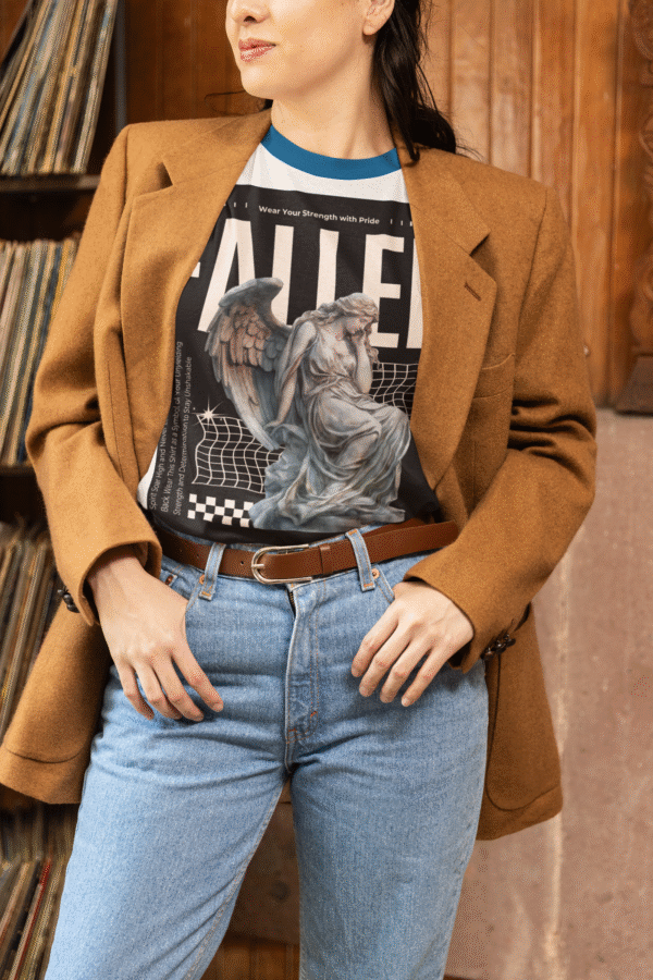 Turn heads with our Fallen Angel Women’s Ringer T-Shirt. Featuring a bold angel statue graphic with the statement "FALLEN," this tee is designed for women who embrace strength and individuality. The contrasting blue collar and sleeve hems add a chic retro touch, while the soft breathable cotton fabric keeps you comfortable all day. Perfect for casual outings, concerts, or weekend hangouts, this tee is a must-have for your wardrobe.